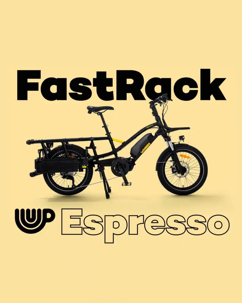En svart Yuba FastRack eldriven lastcykel visas upp mot en gul bakgrund, med den markanta texten ”FastRack” ovanför och ”Espresso” tillsammans med en kaffekopp-ikon nedanför. Yuba FastRack lyfter fram den innovativa Yuba Flexible Longtail-konstruktionen, som erbjuder maximal mångsidighet och en modern stil.