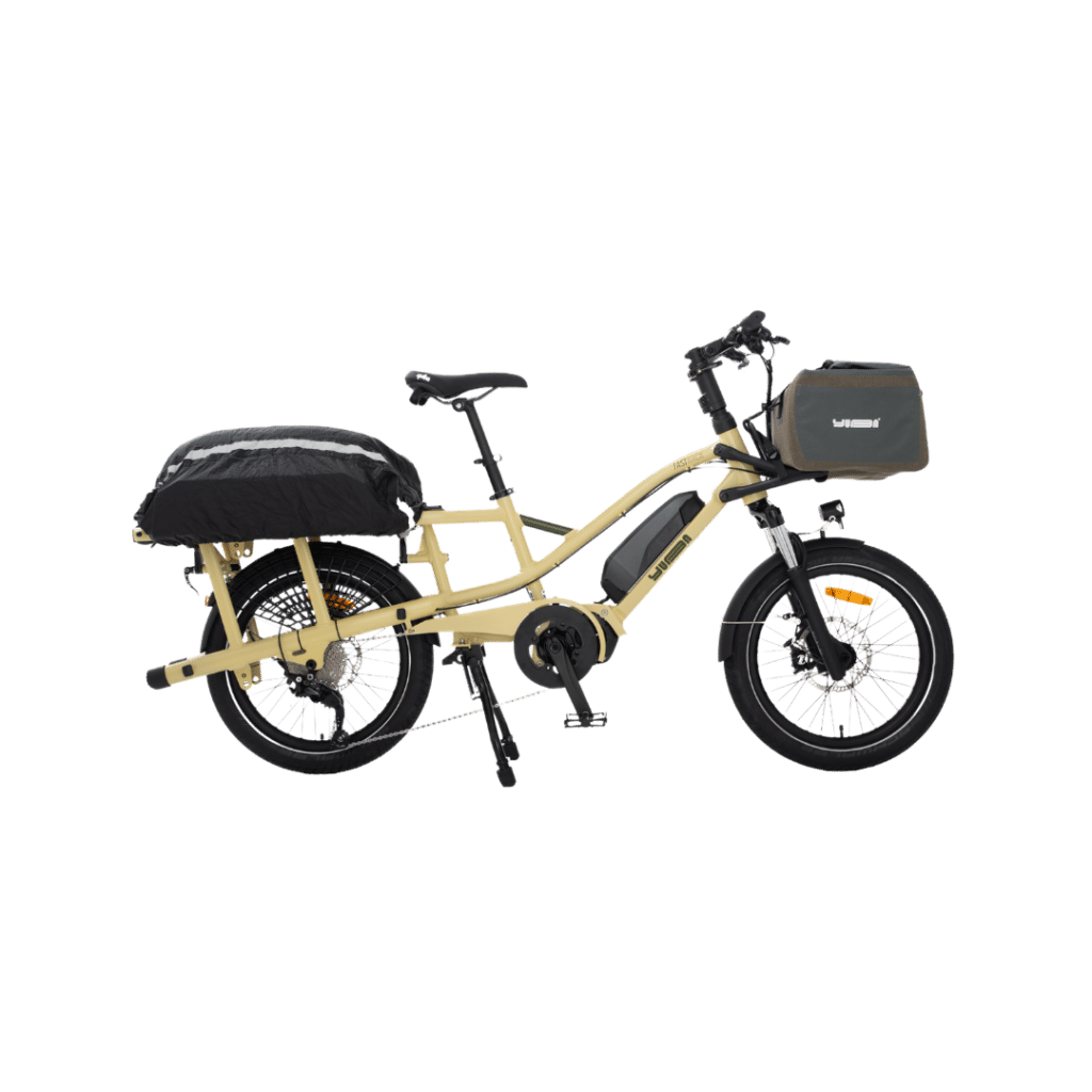 En beige Yuba FastRack eldriven lastcykel med ett bagageutrymme bak med en svart väska och en grön väska framtill fäst vid styret, avbildad mot en vit bakgrund.