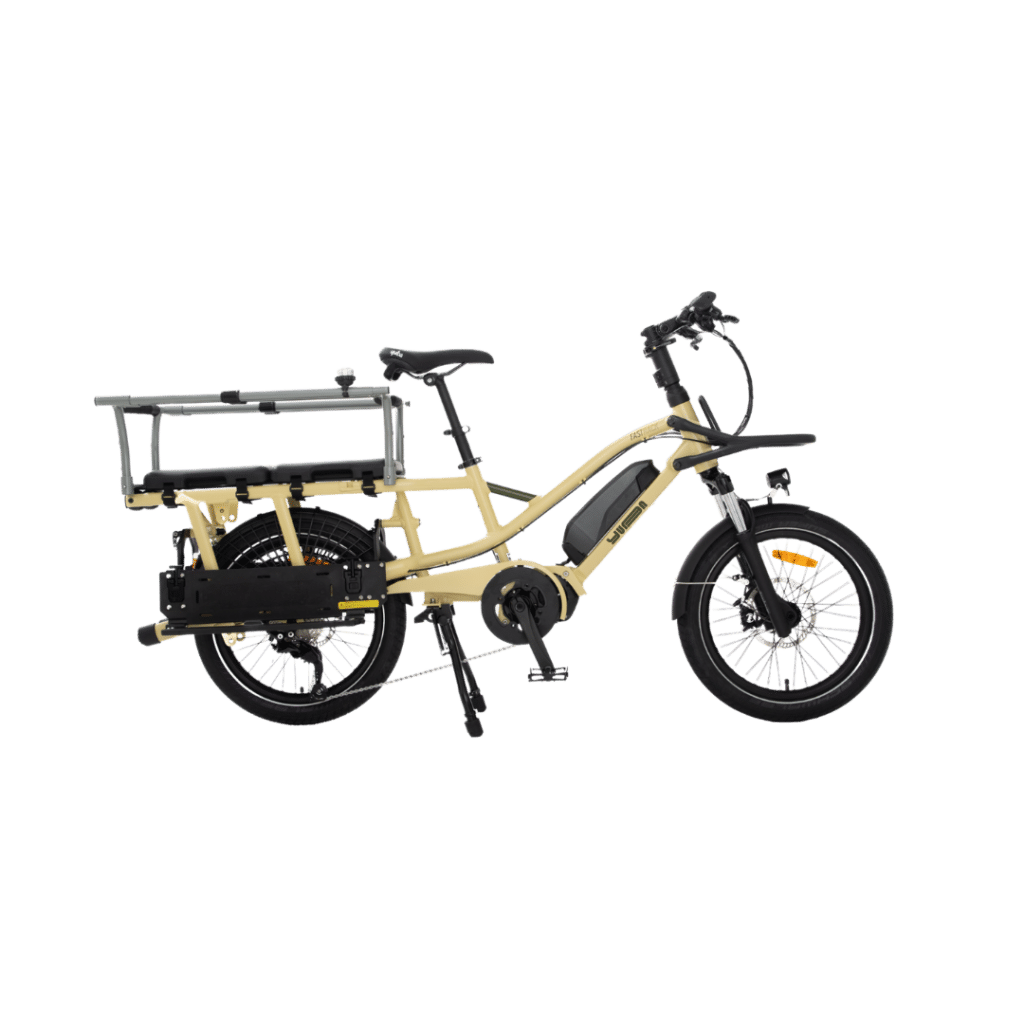 En beige Yuba FastRack eldriven lastcykel med ett robust bakre pakethållare och stänkskärmar visas i profil mot en vit bakgrund. Cykeln har ett batteripaket monterat på ramen och tjocka däck för ökad stabilitet.