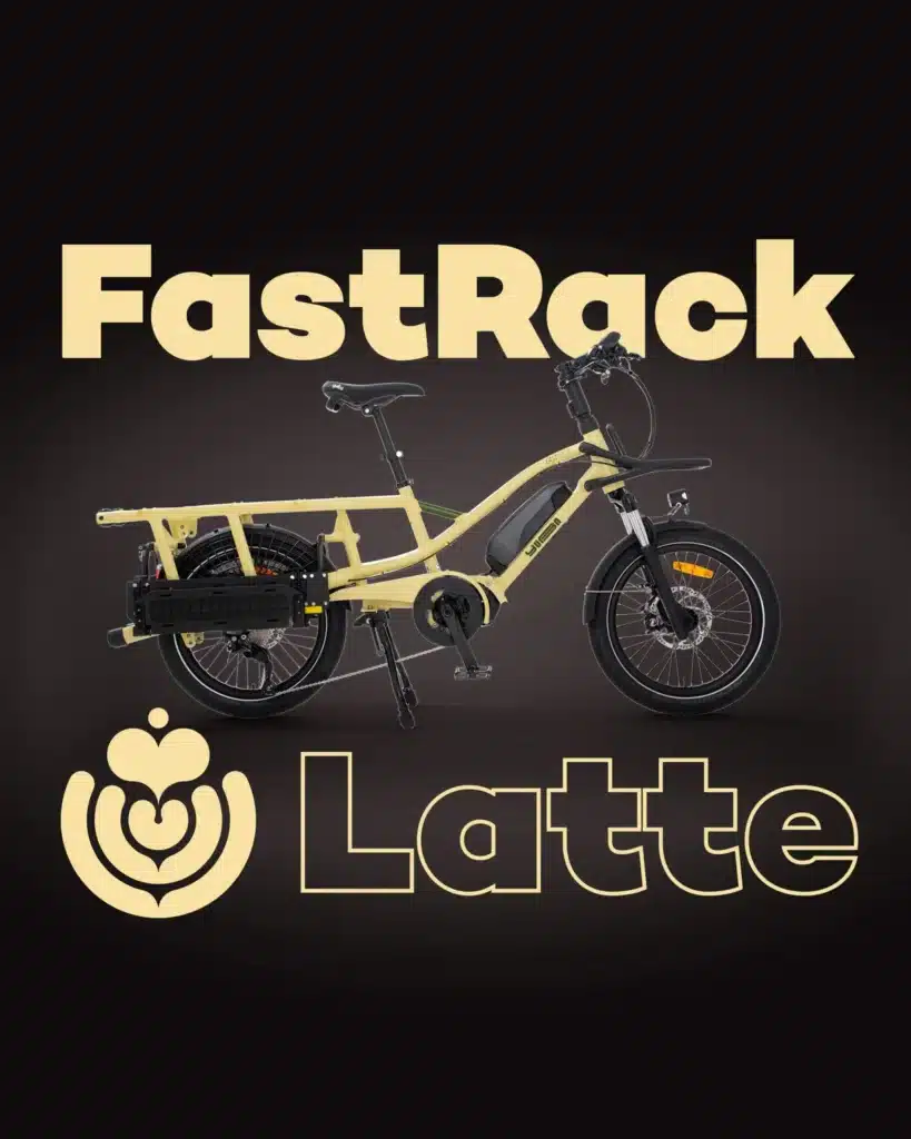 En gul Yuba FastRack-lastcykel med eldrift visas mot en svart bakgrund, med texten ”FastRack” högst upp och ”Latte” tillsammans med en bild av lattekonst längst ner.