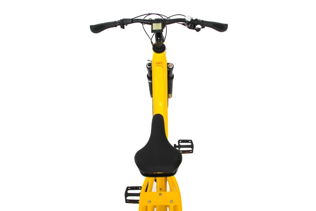 En bild uppifrån av en gul Yuba Spicy Curry Family Edition, en elassiterad longtail-cykel, där styret, den digitala displayen, sadeln och pedalerna syns mot en vit bakgrund.