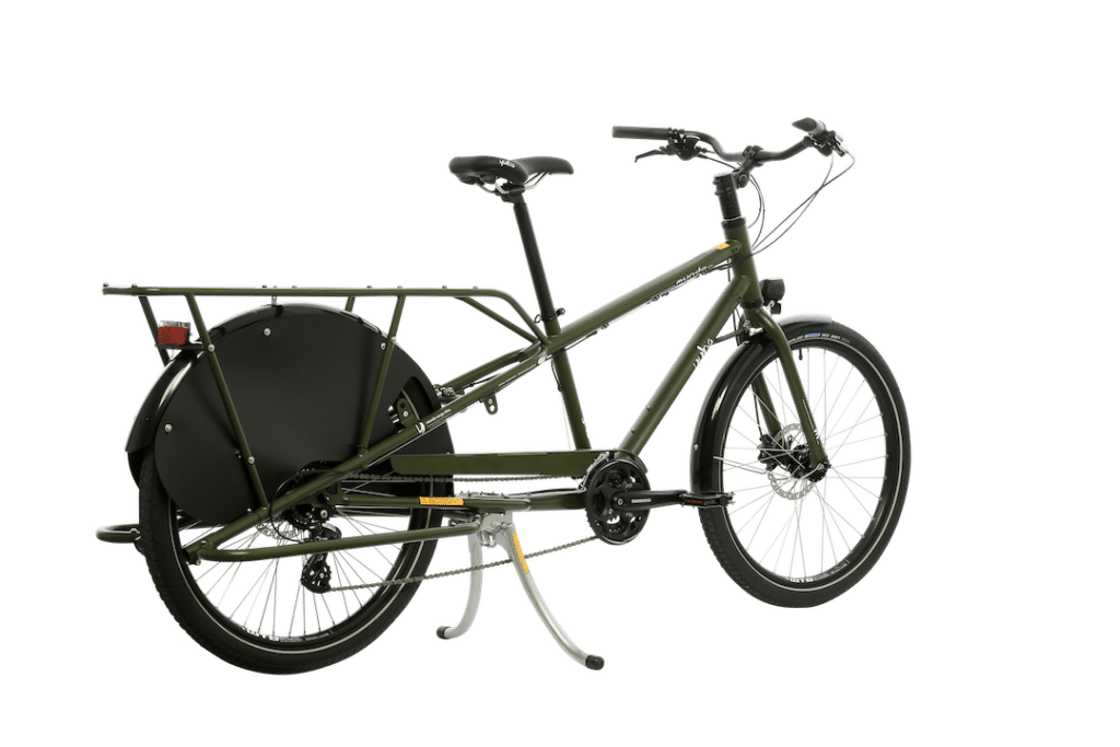 Yuba Mundo Lux är en grön longtail-lastcykel med en stor bakre pakethållare för tunga laster eller passagerare, svarta skärmar, robust dubbelt cykelstöd och hållbar ram – perfekt för familjecykling och stadstransporter.