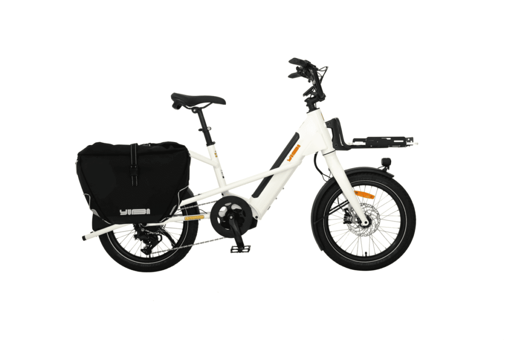 Vit Yuba Mini Boda Boda elektrisk lastcykel med svart bakväska, pakethållare fram, upprätt styre och tjocka däck, vy från sidan.