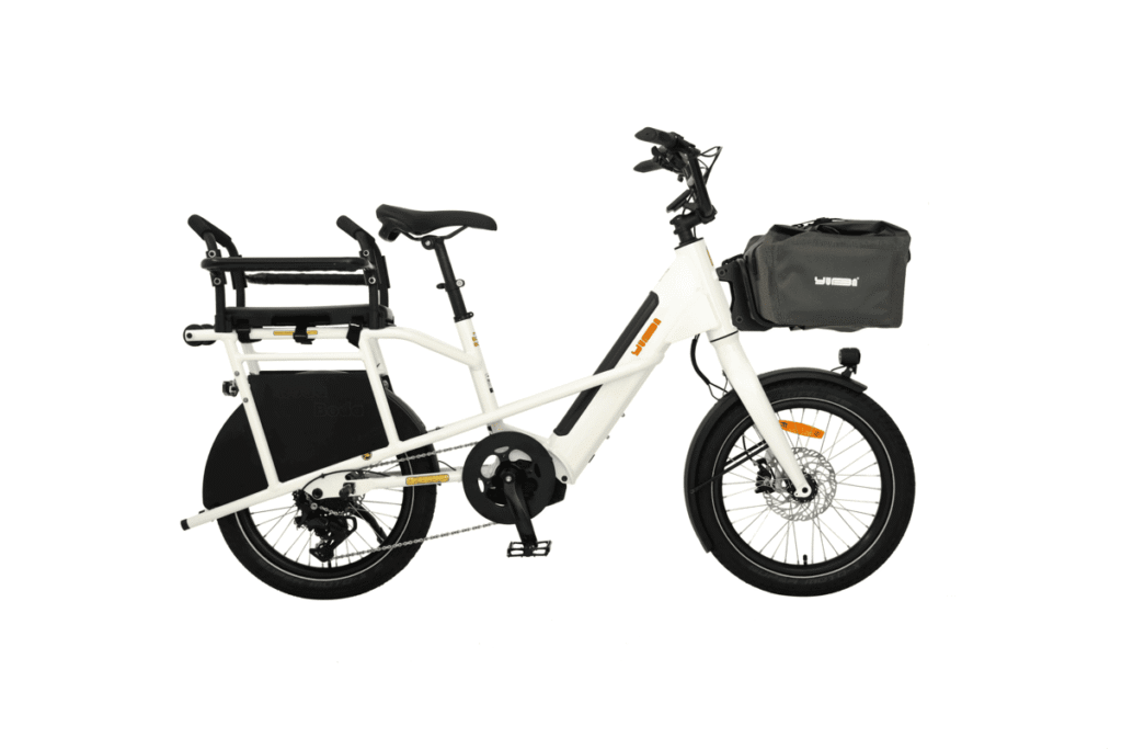 Vit Yuba Mini Boda Boda elektrisk lastcykel med två hjul, förvaringsväska fram och passagerarsäte bak visas i profil mot vit bakgrund.