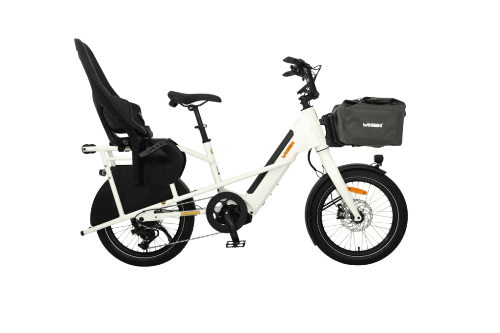 Vit Yuba Mini Boda Boda e-cargo cykel med barnstol bak och stor förvaringsväska fram, mot en vit bakgrund.