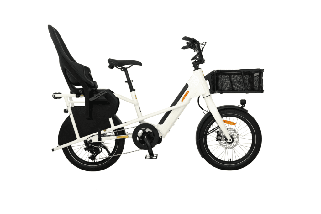 Vit Yuba Mini Boda Boda-cykel med svart lastkorg fram och barnstol bak, visad i profil mot en vit bakgrund.