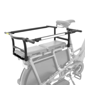 Ett kompakt cykelställ i svart metall med skenor och sidostöd är monterat ovanför bakhjulet på en cykel, som visas i delvis gråskala. Laststället verkar vara utformat för att transportera last eller passagerare på ett säkert sätt och är idealiskt för användning med Yuba EZ Monkeybars.