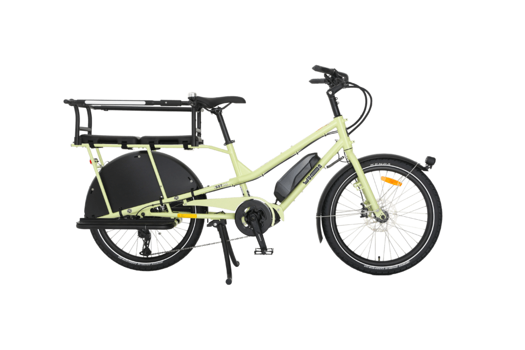 Yuba Kombi EP5, en gul eldriven lastcykel, har två hjul, ett robust bakre pakethållare, ett stöd, skärmar fram och bak, och avbildas i sidoprofil mot en vit bakgrund.