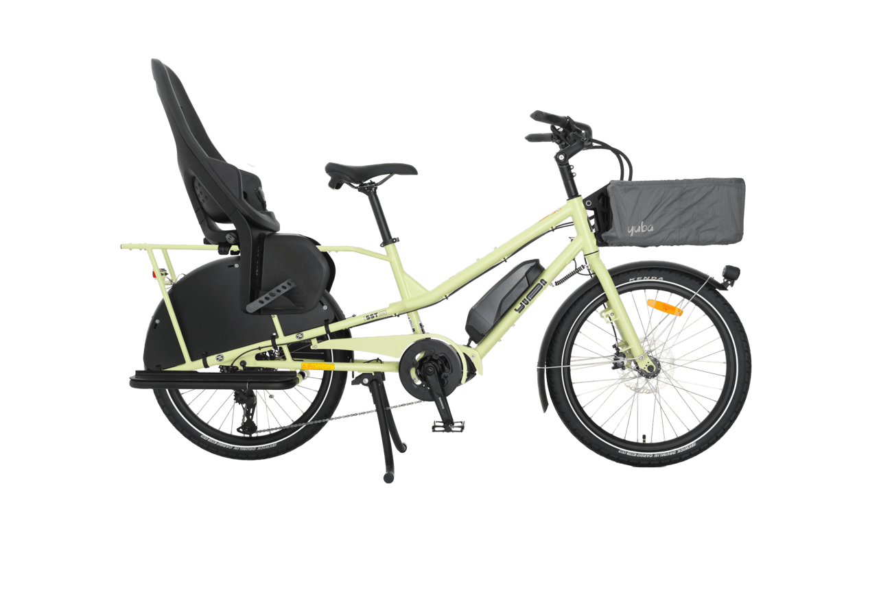 Den ljusgröna eldrivna lastcykeln Yuba Kombi EP5 visas från sidan mot en vit bakgrund, med en rymlig korg framtill och en barnstol monterad ovanför bakhjulet.